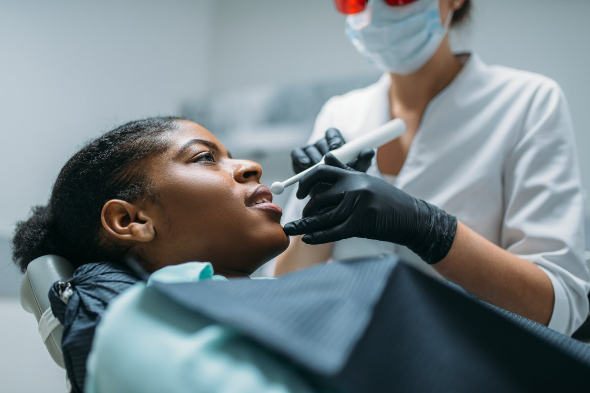Dentist performing oral examination on patient during cosmetic dental treatment in Carrollton.
